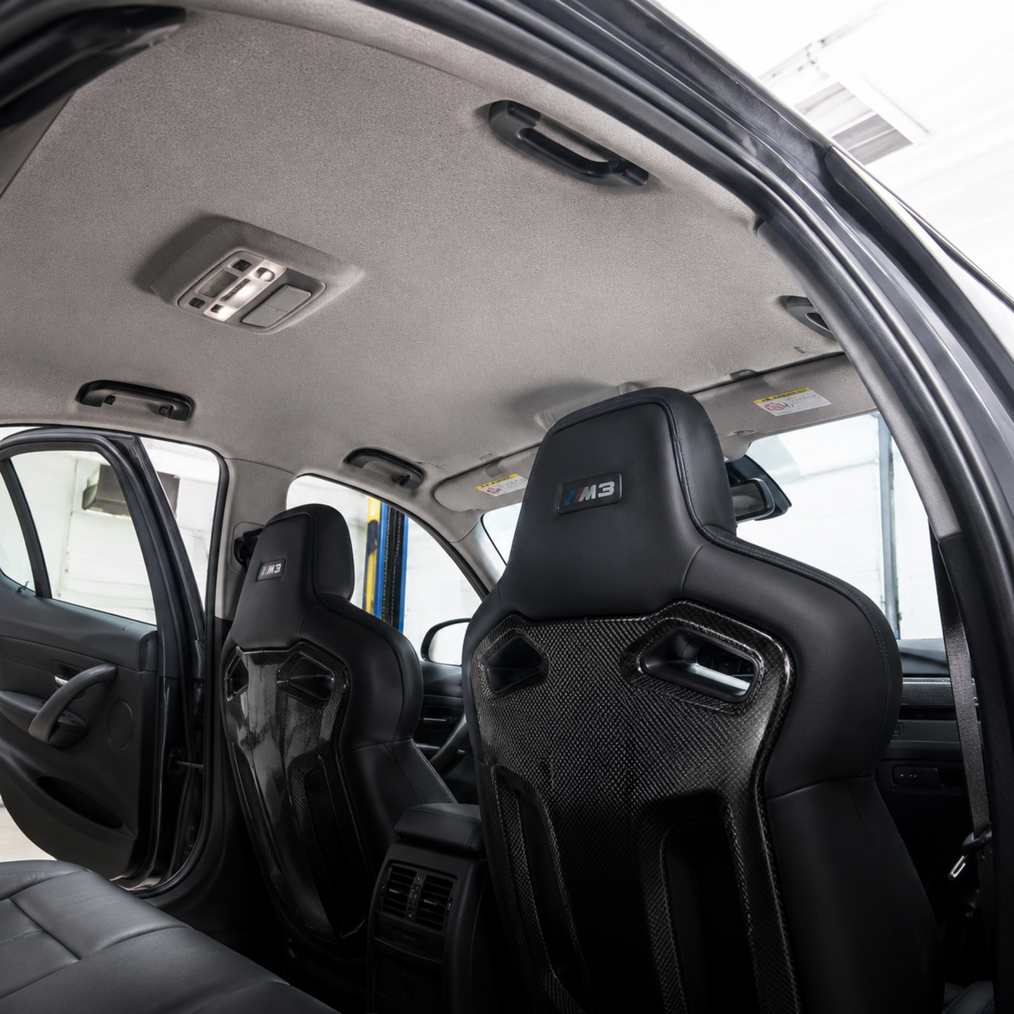 Finished BMW F80 M3 interior showing a professionally installed smooth Light Gray Headliner Magic replacement headliner